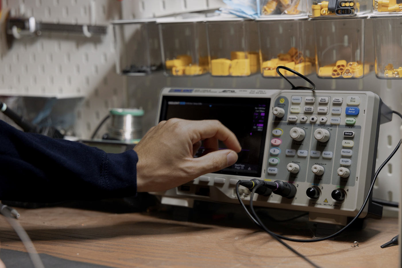 Engineer using an oscilloscope for electronics development and signal validation